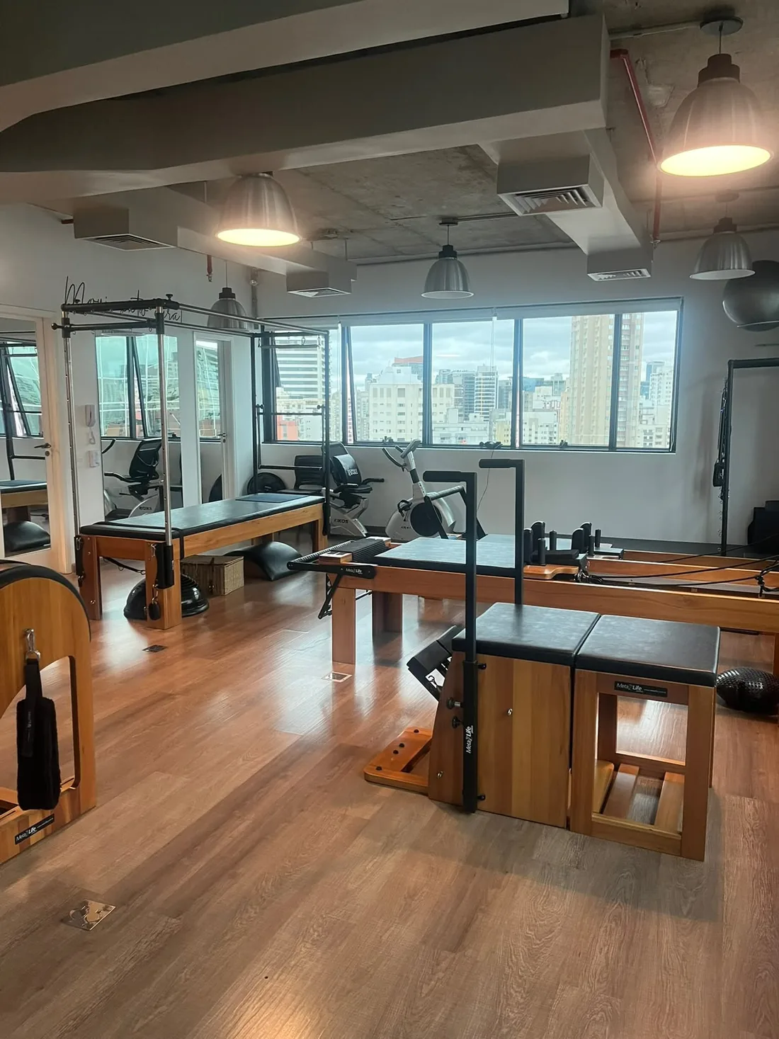Estúdio MOV UP com aparelhos de pilates e janelas amplas com vista para Vila Nova Conceição